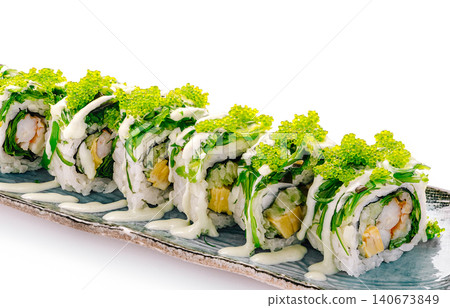 Uramaki sushi rolls topped with green tobiko and sauce Uramaki sushi rolls topped with green tobiko and sauce 140673849