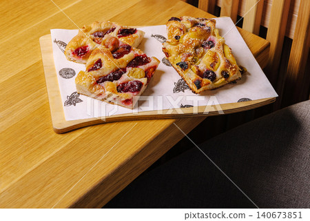 Fresh fruit focaccia dessert slices on wooden table Fresh fruit focaccia dessert slices on wooden table 140673851