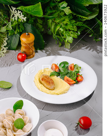 Mashed potatoes with cutlet, pelmeni, and fresh salad Mashed potatoes with cutlet, pelmeni, and fresh salad 140673922