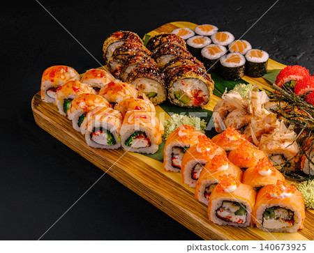 Assorted sushi and uramaki rolls serving on wooden board Assorted sushi and uramaki rolls serving on wooden board 140673925