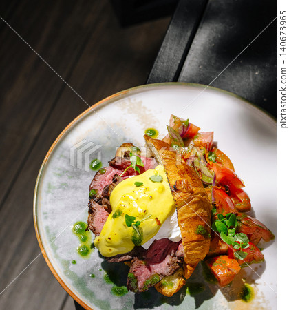 Gourmet brunch plating steak croissant egg benedict Gourmet brunch plating steak croissant egg benedict 140673965