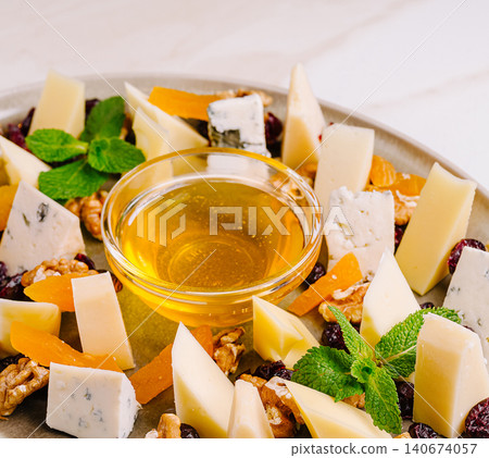 Elegant cheese platter with honey and dried fruit Elegant cheese platter with honey and dried fruit 140674057