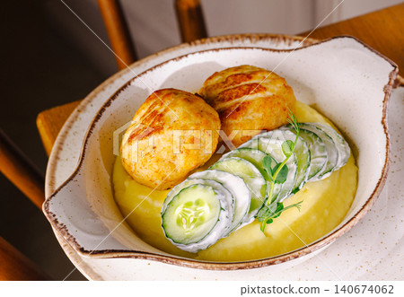 Chicken cutlets with creamy mashed potatoes and sliced cucumbers Chicken cutlets with creamy mashed potatoes and sliced cucumbers 140674062