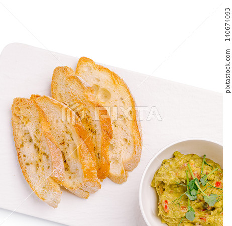 Baguette slices with fresh guacamole dip on board 140674093