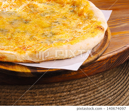 Four cheese pizza cooking on wooden board Four cheese pizza cooking on wooden board 140674097