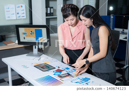 Creative team brainstorming digital marketing strategy, two asian woman discussing branding and online business growth. Creative team brainstorming digital marketing strategy, two asian woman discussing branding and online business growth. 140674123