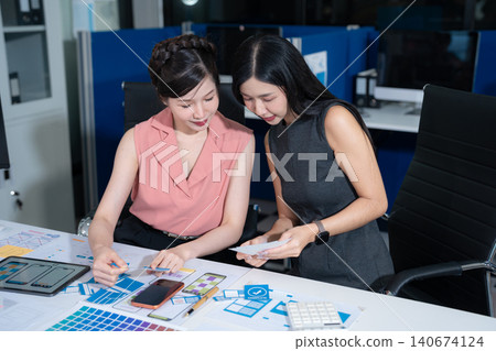 Creative team brainstorming digital marketing strategy, two asian woman discussing branding and online business growth. Creative team brainstorming digital marketing strategy, two asian woman discussing branding and online business growth. 140674124