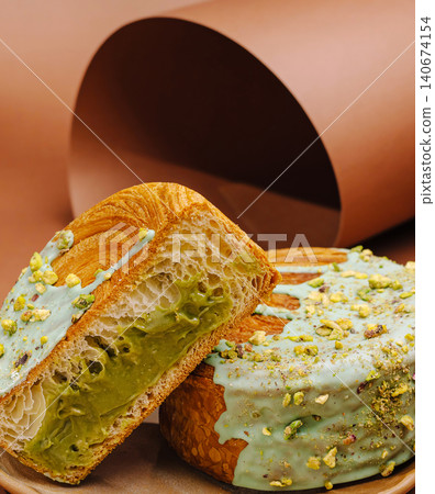 Pistachio croissant flat lay with cream and nuts Pistachio croissant flat lay with cream and nuts 140674154
