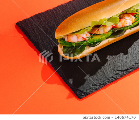 Shrimp sub sandwich with avocado on slate plate 140674170