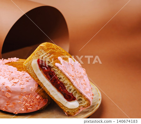 Croissant doughnut hybrid pastry with pink icing and fruit filling Croissant doughnut hybrid pastry with pink icing and fruit filling 140674183