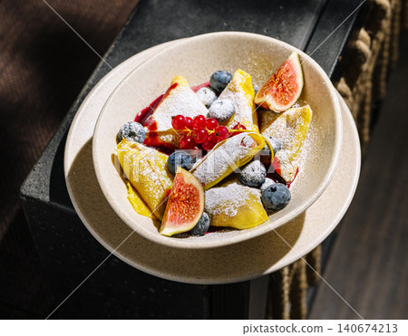 Crepes with berries, fruits, and powdered sugar 140674213