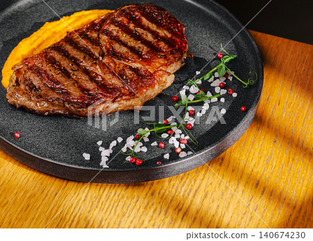 Grilled ribeye steak serving with sweet potato puree Grilled ribeye steak serving with sweet potato puree 140674230