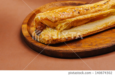 Sausage roll with puff pastry on wooden plate 140674302