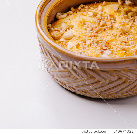 Baked pudding dessert with nuts in ceramic bowl Baked pudding dessert with nuts in ceramic bowl 140674322