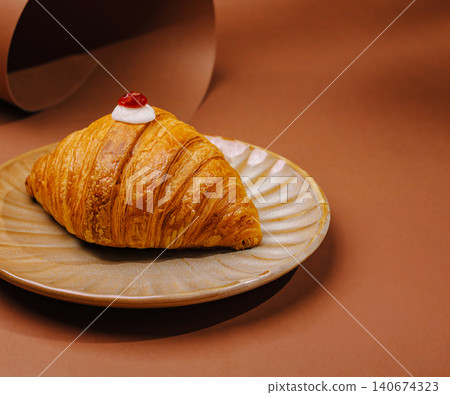 Croissant with cream and cherry on plate 140674323