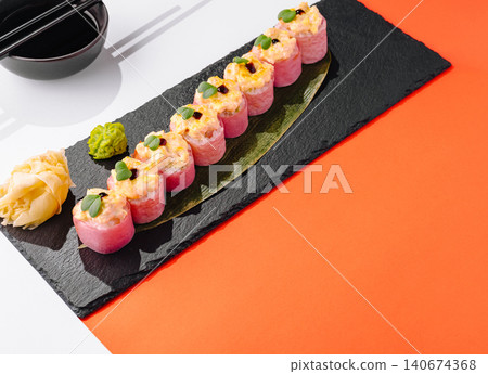 Baked sushi rolls with salmon on black slate Baked sushi rolls with salmon on black slate 140674368