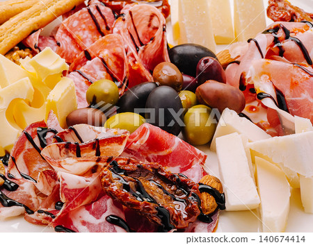 Charcuterie board offering cheeses, salami, prosciutto, and olives Charcuterie board offering cheeses, salami, prosciutto, and olives 140674414