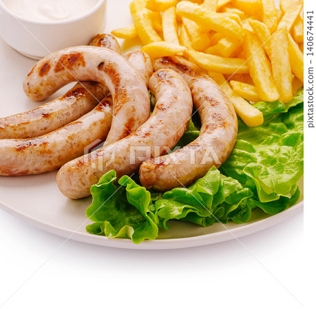 Grilled chicken sausages with french fries and lettuce Grilled chicken sausages with french fries and lettuce 140674441