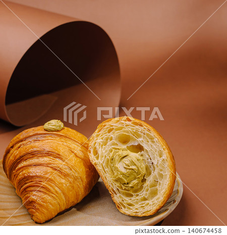 Pistachio croissant showing flaky pastry and green filling 140674458