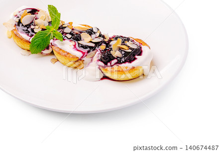 Syrniki pancakes with blueberry jam, cream, almonds, and mint Syrniki pancakes with blueberry jam, cream, almonds, and mint 140674487