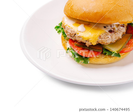Cheeseburger with beef patty, melted cheese, and vegetables on white plate Cheeseburger with beef patty, melted cheese, and vegetables on white plate 140674495