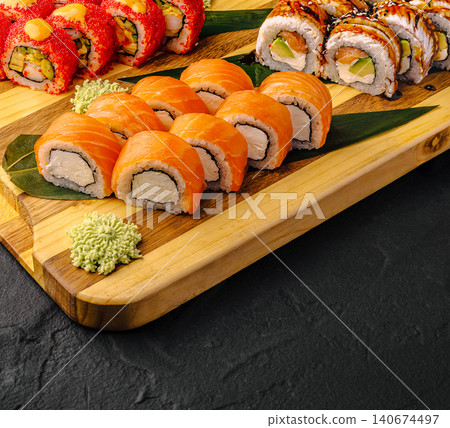 Assortment of fresh sushi rolls on wooden board Assortment of fresh sushi rolls on wooden board 140674497