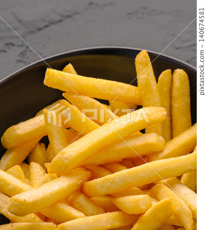 Heap of golden salted french fries in bowl Heap of golden salted french fries in bowl 140674581