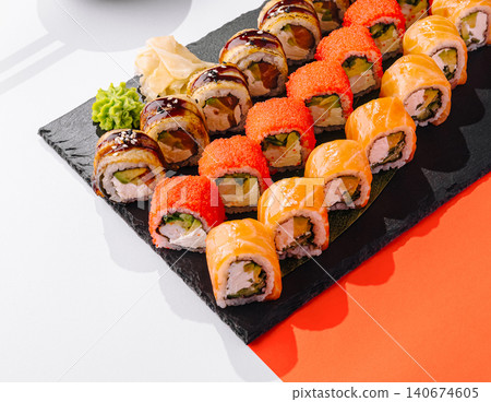 Assortment of fresh sushi rolls on a black platter 140674605