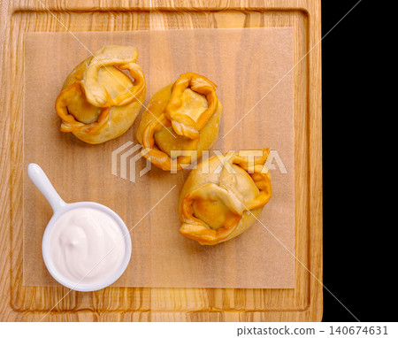 Steaming dumplings on parchment paper with sour cream Steaming dumplings on parchment paper with sour cream 140674631