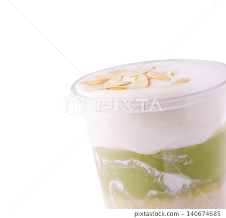Matcha latte topped with almond flakes and foam Matcha latte topped with almond flakes and foam 140674685