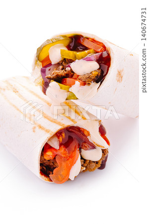 Beef shawarma wraps stacked with fresh vegetables and sauces Beef shawarma wraps stacked with fresh vegetables and sauces 140674731