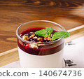Panna cotta dessert with berry sauce, nuts, and mint 140674736