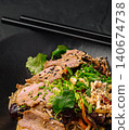 Asian noodle dish with beef, vegetables, and sesame 140674738