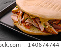 Shawarma flatbread sandwich with roasted chicken and sauce 140674744