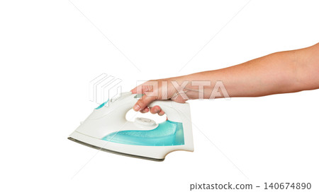 a female hand horizontally holds a modern white iron with turquoise details a female hand horizontally holds a modern white iron with turquoise details 140674890