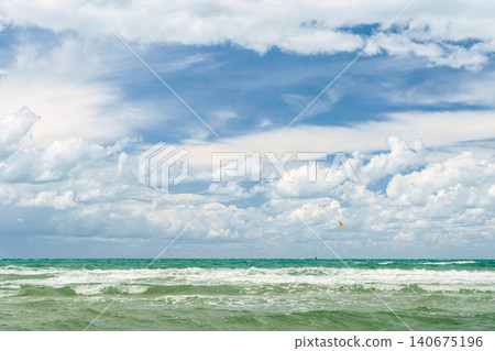 Stormy seas and strong winds, time for windsurfing and active holidays on the coast, copy space for text and the concept of the summer holiday season Stormy seas and strong winds, time for windsurfing and active holidays on the coast, copy space for text and the concept of the summer holiday season 140675196