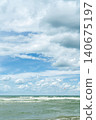 vertical poster with a sea view, wind and waves near the shore, time for windsurfing and active recreation during the summer vacation season 140675197