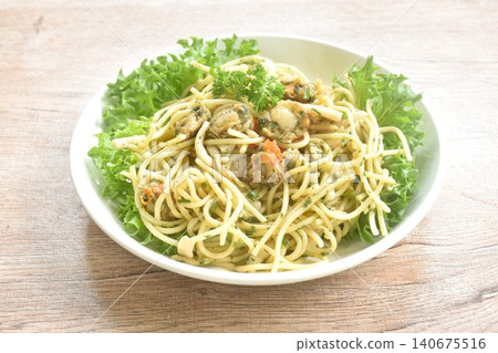 spicy stir fried spaghetti with scallop in garlic butter sauce with vegetable salad on plate spicy stir fried spaghetti with scallop in garlic butter sauce with vegetable salad on plate 140675516