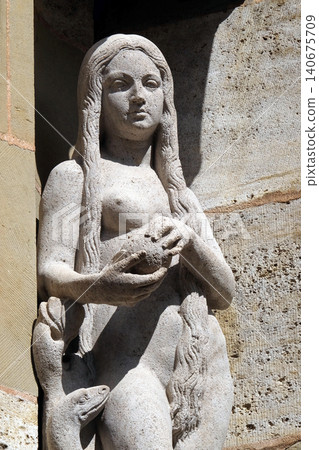 Eve with snake, statue on facade of the St James Church in Rothenburg ob der Tauber, Germany Eve with snake, statue on facade of the St James Church in Rothenburg ob der Tauber, Germany 140675709