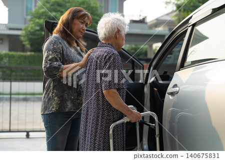 Caregiver help Asian elderly woman disability patient get in her car. Caregiver help Asian elderly woman disability patient get in her car. 140675831