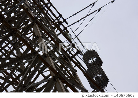 Complex steel truss construction of a radio tower against overcast sky Complex steel truss construction of a radio tower against overcast sky 140676602