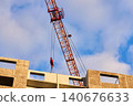 Orange tower crane jib with trolley and pulleys in action 140676633