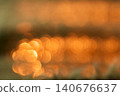 Burred sunset reflections on water creating golden sparkles 140676637