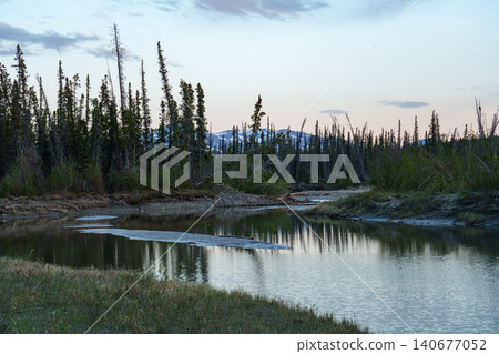 A stunning natural landscape near Haines Junction in the Yukon Territory, Canada, featuring a beautiful river and sunrise in the early morning. A must-see tourist attraction. 140677052