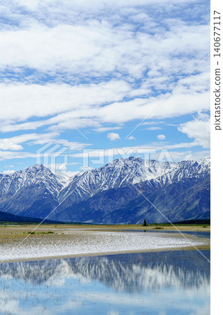 Kluane National Park in Yukon Territory, Canada: A breathtaking landscape featuring the Kluane Mountains and the beautiful reflection of Lake Kluane. A must-see tourist attraction. 140677117