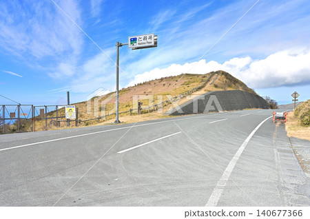 伊豆半島伊豆山脊步道上的仁名峠:一條穿過草原的山脊步道,橫越公路。 伊豆半島伊豆山脊步道上的仁名峠:一條穿過草原的山脊步道,橫越公路。 140677366