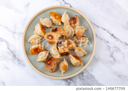 Golden pan-fried Chinese dumplings Jiaozi with premium sea cucumber and shrimp filling Golden pan-fried Chinese dumplings Jiaozi with premium sea cucumber and shrimp filling 140677709