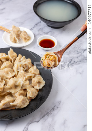 Traditional Chinese dumplings Jiaozi with pork and sauerkraut filling served with dipping sauce Traditional Chinese dumplings Jiaozi with pork and sauerkraut filling served with dipping sauce 140677713
