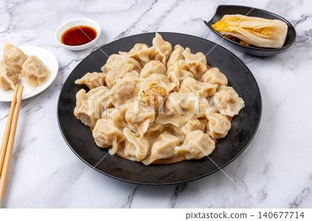 Traditional Chinese dumplings Jiaozi with pork and sauerkraut filling served with dipping sauce Traditional Chinese dumplings Jiaozi with pork and sauerkraut filling served with dipping sauce 140677714