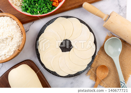 Round homemade Chinese dumpling wrappers arranged neatly on plate for making Jiaozi 140677721